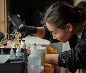 A researcher measures water quality on an oyster reef at eye level.