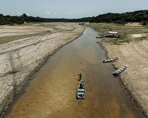 A man pulls a boat through the shallow centre of a river near the community of Sao Francisco de Marina which has been cut off due to low water levels in local rivers. 