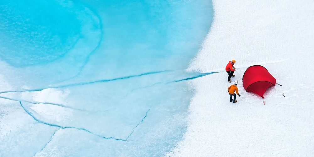 2 people and a rent tent on a snowy glacier.